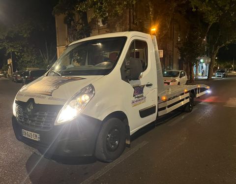 Camion plateau Renault Master SO DEPANNE avec un véhicule chargé lors d'une intervention de nuit