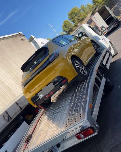Peugeot 208 jaune chargée sur le plateau de dépannage SO DEPANNE